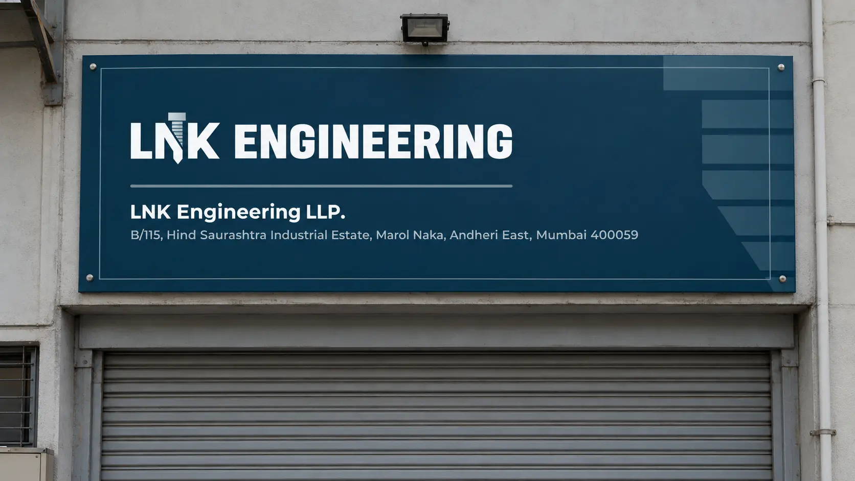 The navy LNK Engineering sign above the grey rolling shutter of a unit in a Mumbai industrial estate.
