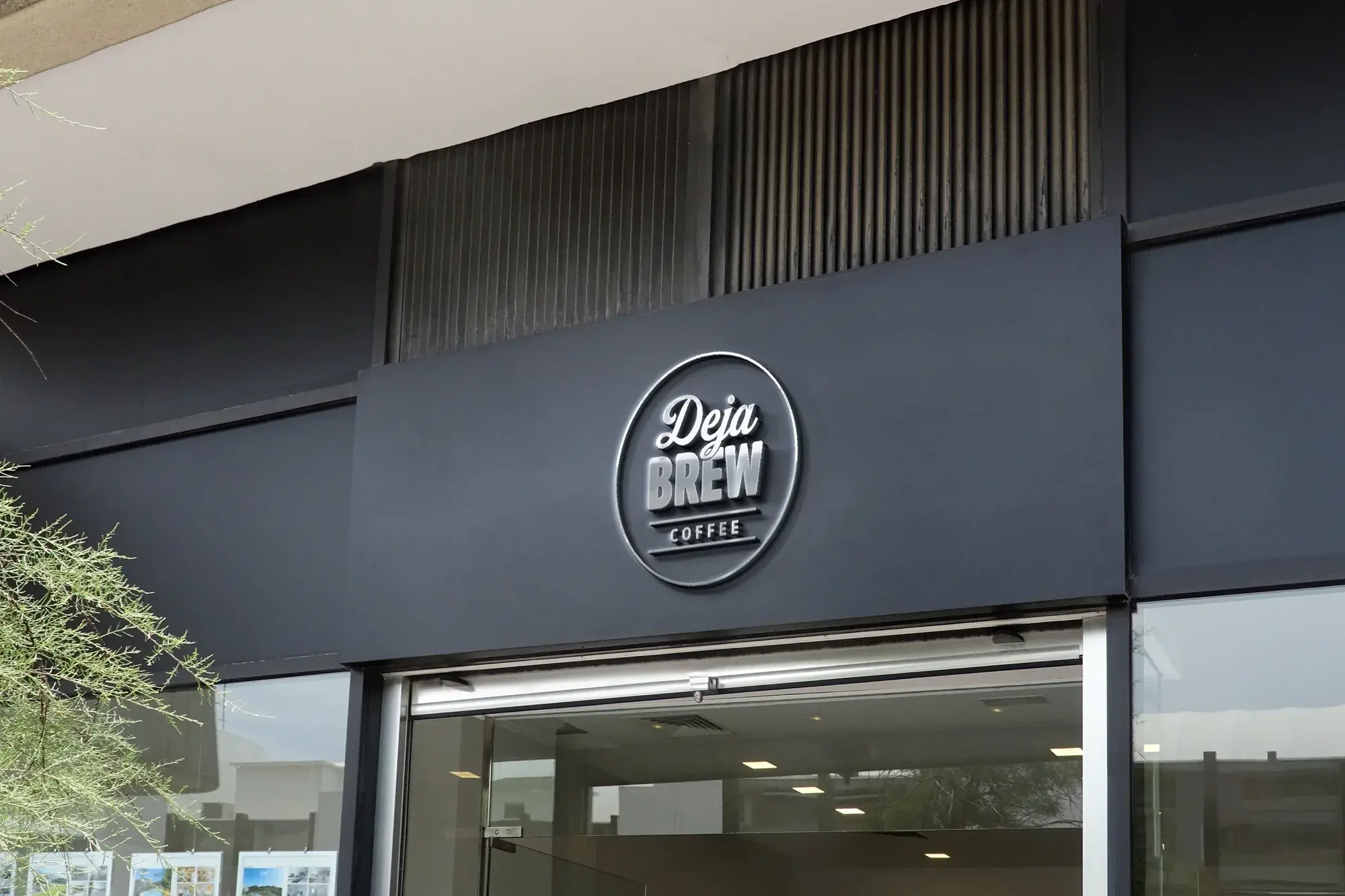 Mock-up: the badge as a raised sign on a dark grey shopfront.