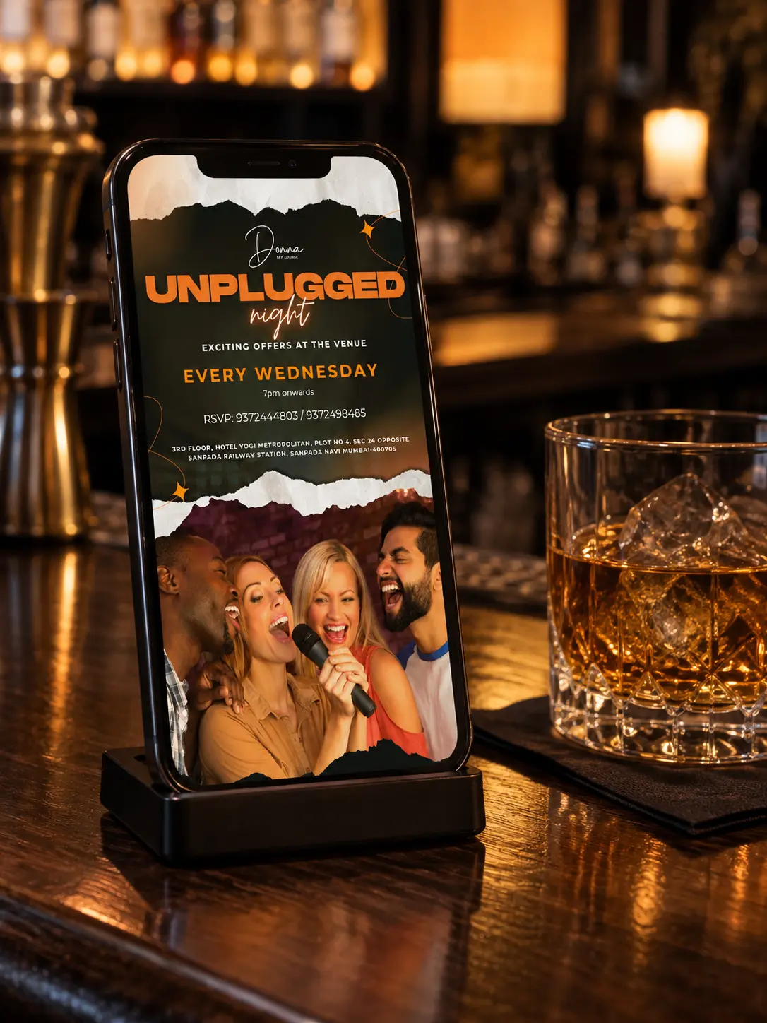 The Unplugged Night story on a phone standing on a dark bar counter beside an amber drink
