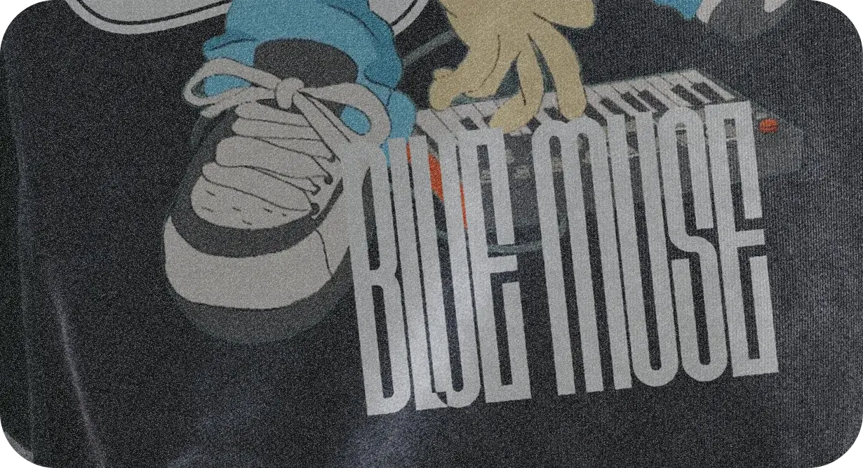 Close-up of the hoodie print: a sneaker, the keyboard and BLUE MUSE in tall condensed letters.