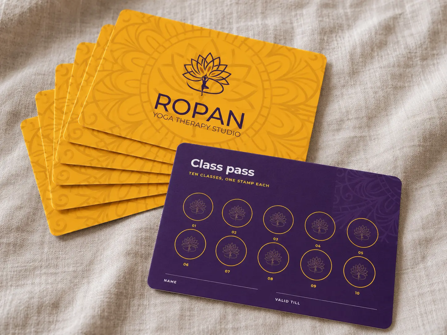 Amber Ropan class passes fanned on linen, one turned over to its purple back with ten stamp circles.