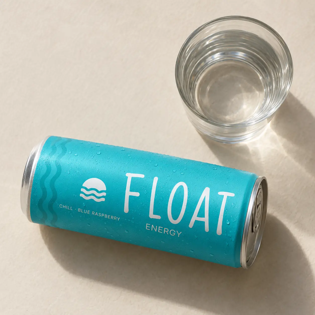 The Chill Blue Raspberry can lying on its side on cream paper next to a glass of water