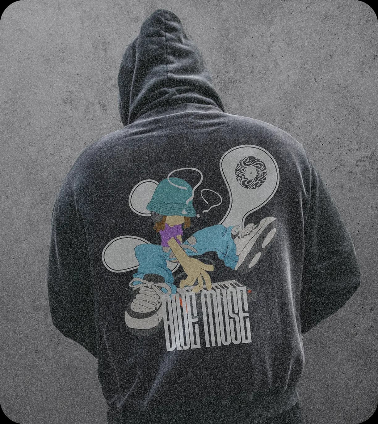 A washed charcoal hoodie from behind, printed with a character at a MIDI keyboard, two speech-bubble shapes, the mark and BLUE MUSE in tall letters.