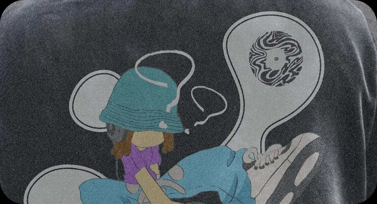 Close-up of the hoodie print: the character in a bucket hat, and the mark inside a bubble.