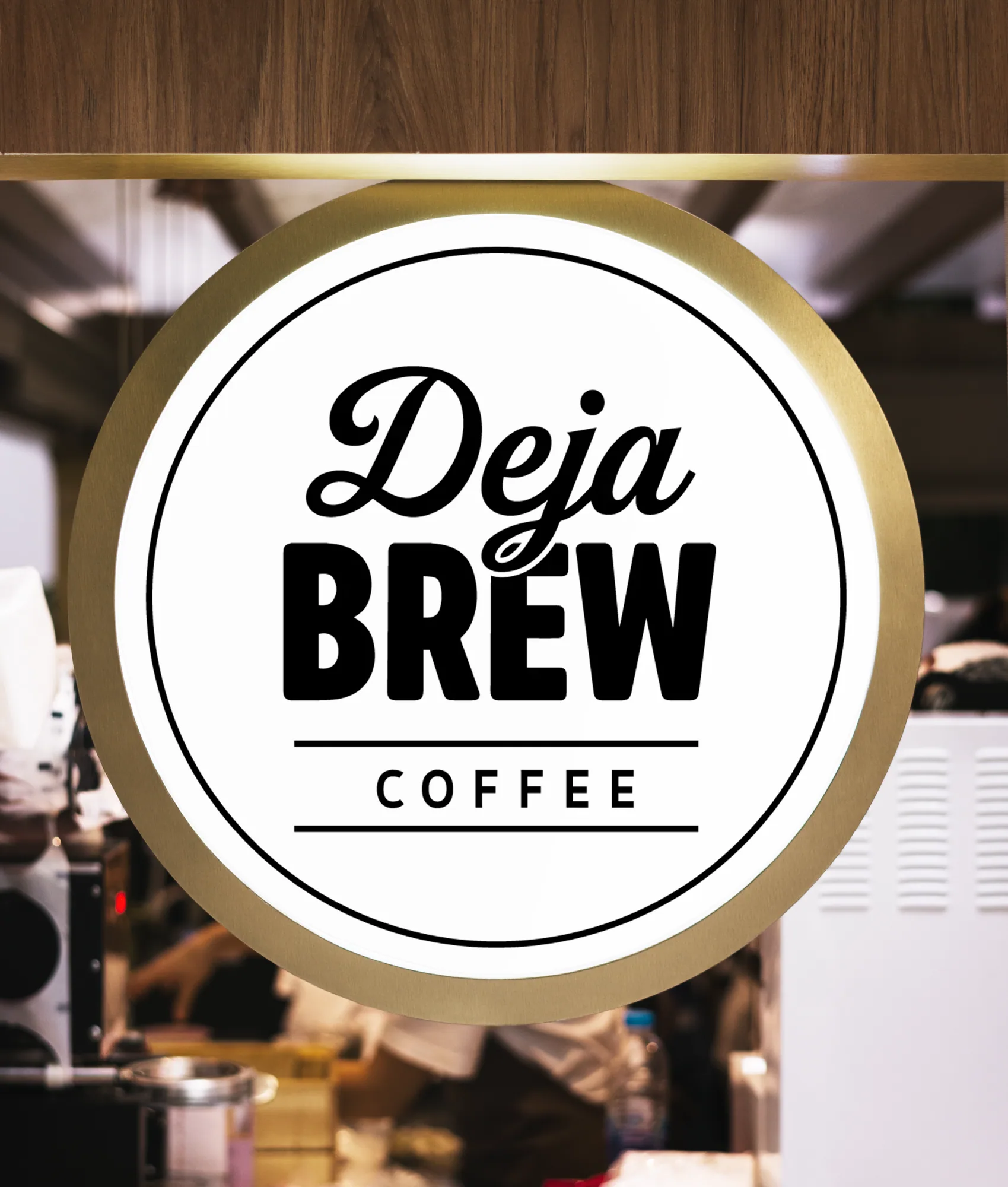 Mock-up: a round lit sign with the badge in a brass ring, hung over a café counter.