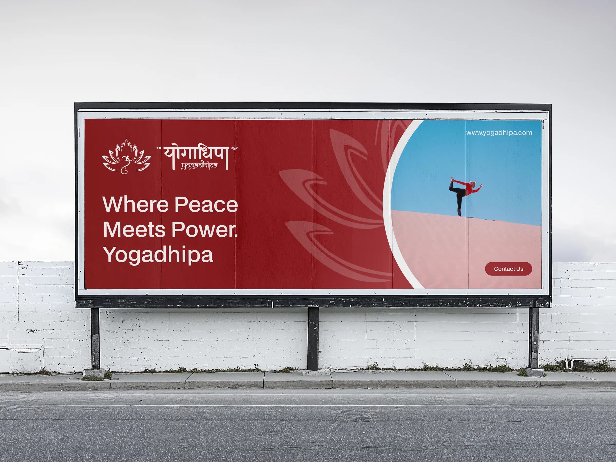The Yogadhipa billboard by a road: ‘Where Peace Meets Power. Yogadhipa’ in white on crimson, beside a photograph of a woman in a standing balance against a blue sky.
